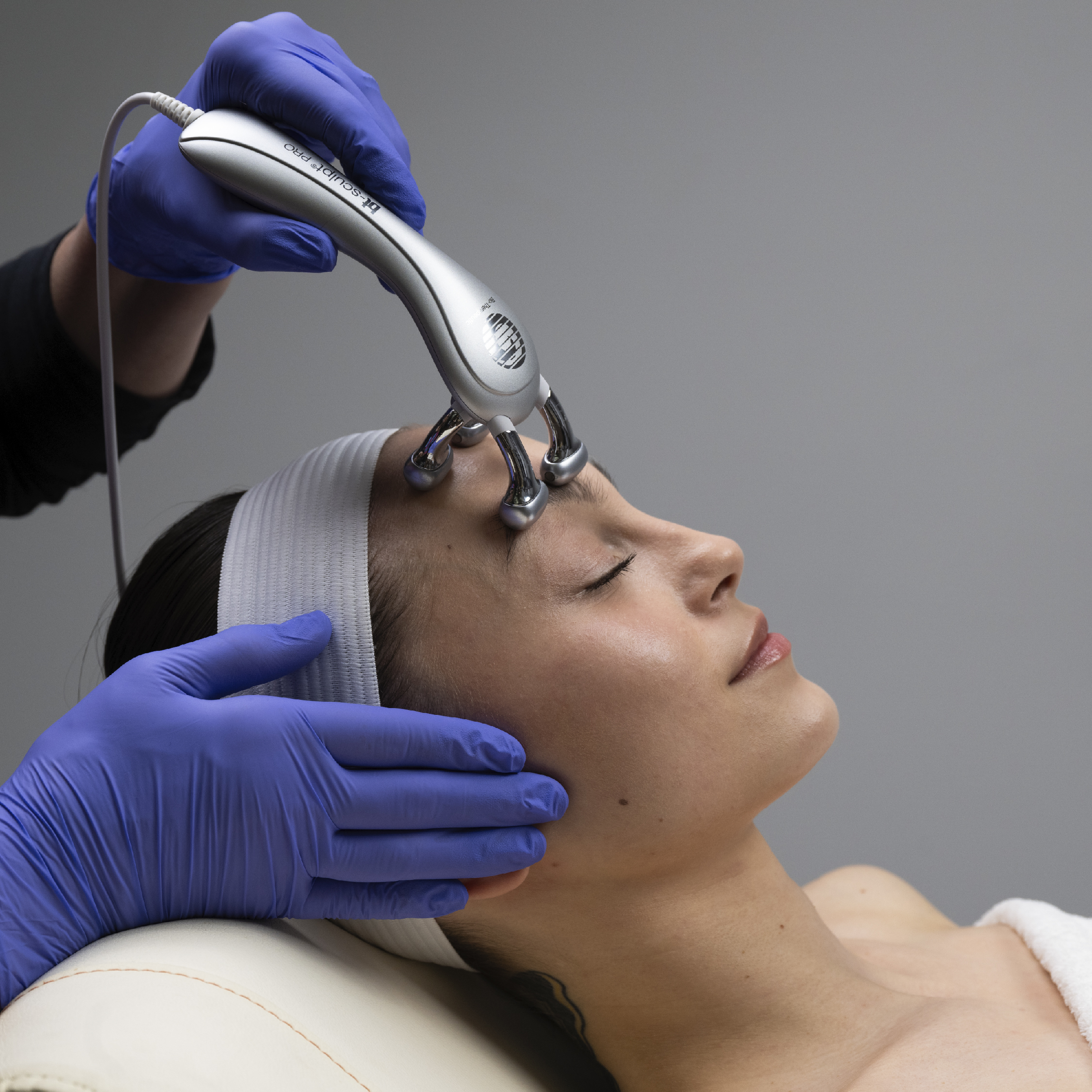 A woman getting her face cleaned by an esthetician.